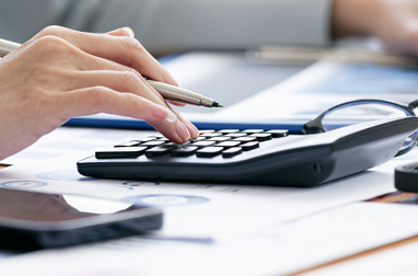 pic of a hand using a calculator to work out expenses